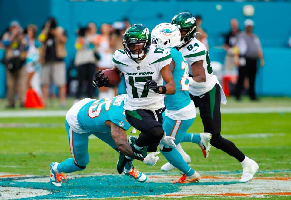 New York Jets wide receiver Garrett Wilson (17) is being tackled by Miami Dolphins cornerback Xavien Howard (25) during third quarter of an NFL football game at Hard Rock Stadium on Sunday, January 8, 2023 in Miami Gardens, Florida.