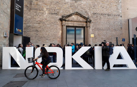 FILE PHOTO: A cyclist rides past a Nokia logo during the Mobile World Congress in Barcelona, Spain February 25, 2018. REUTERS/Yves Herman/File Photo