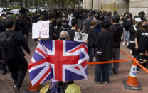 A woman holds a British flag as supporters queue up outside a court to try get in for a hearing in Hong Kong Monday, March 1, 2021. People gathered outside the court Monday to show support for 47 activists who were detained over the weekend under a new national security law that was imposed on the city by Beijing last year. (AP Photo/Vincent Yu)