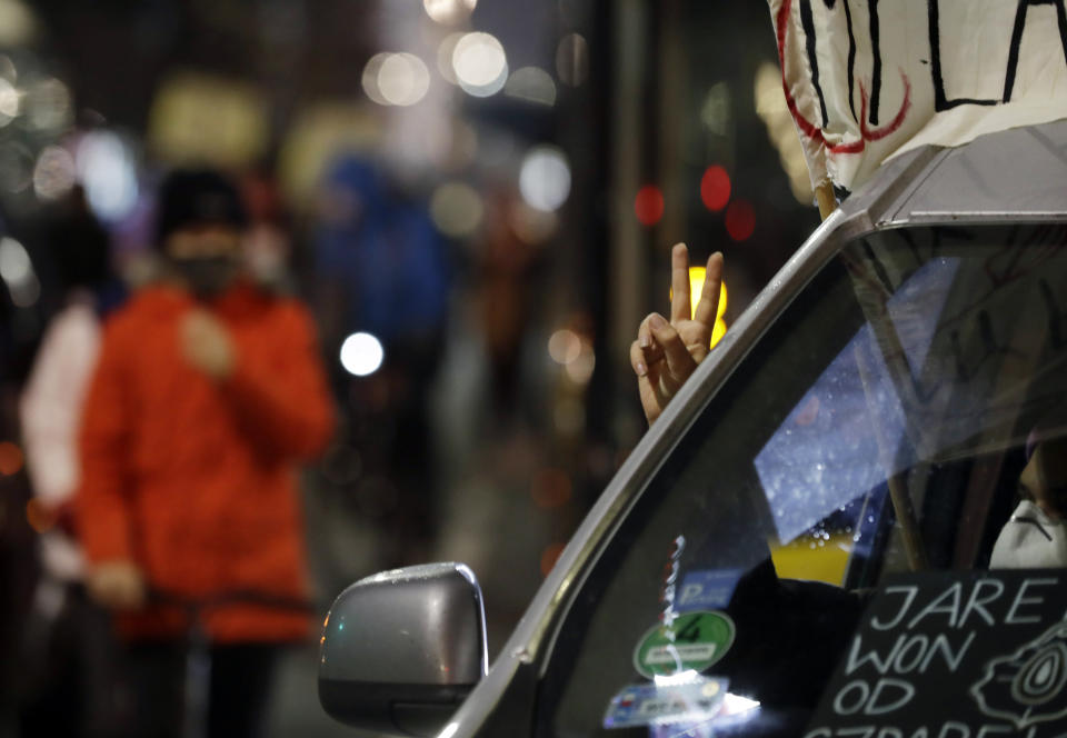 A protester flashes victory sign from inside a car, in downtown Warsaw, Monday, Nov. 9, 2020, on the 12th straight day of anti-government protests that were triggered by the tightening of Poland's strict abortion law and are continuing despite a anti-COVID-19 ban on public gatherings. (AP Photo/Czarek Sokolowski)