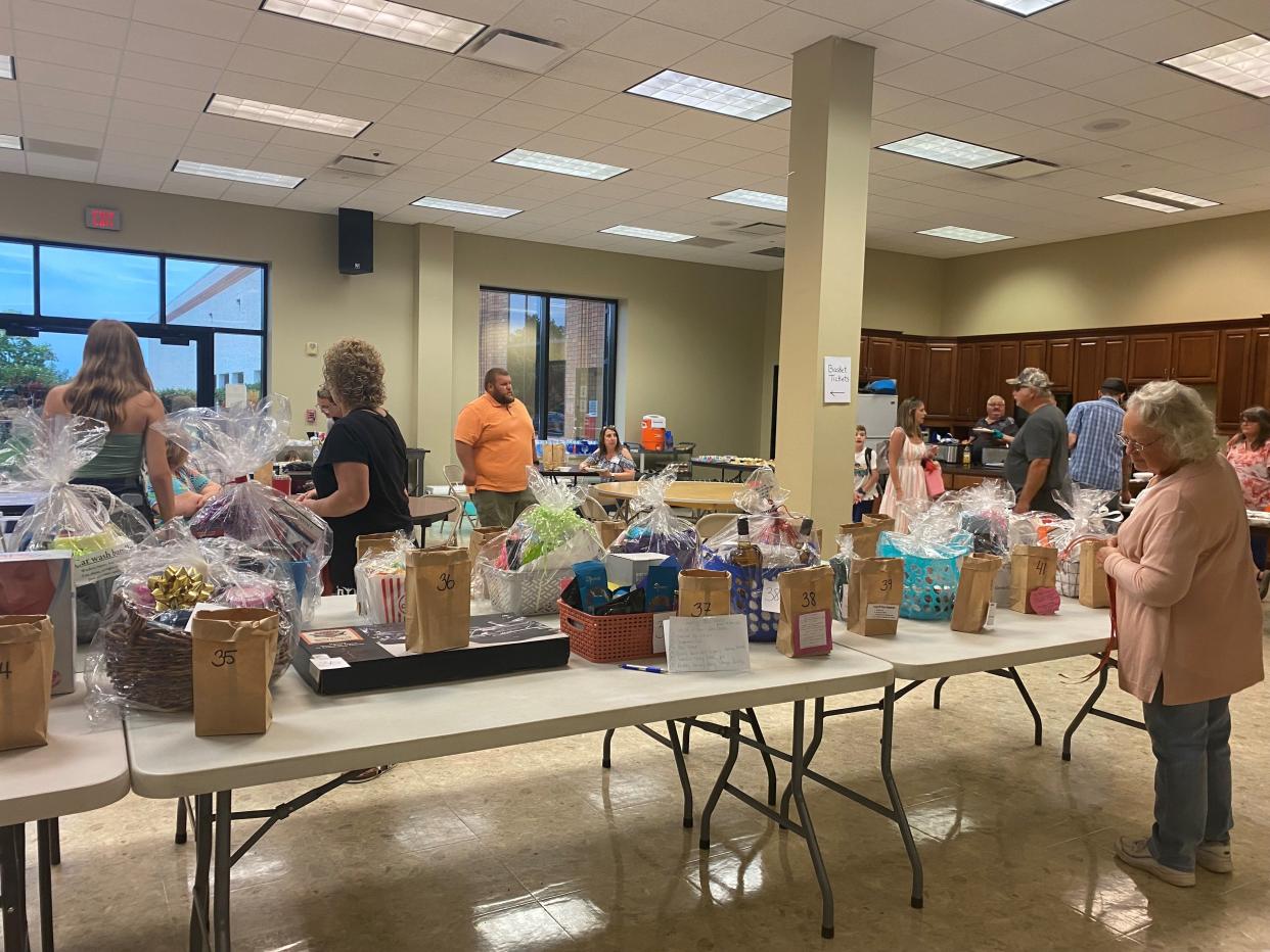 Attendees look at raffle items during the benefit dinner for Larry Nichols at Robertson Heating Supply on Saturday, June 25, 2022.