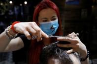 Barber Kinga Rutkowska, 22, cuts hair at a barbershop in Warsaw