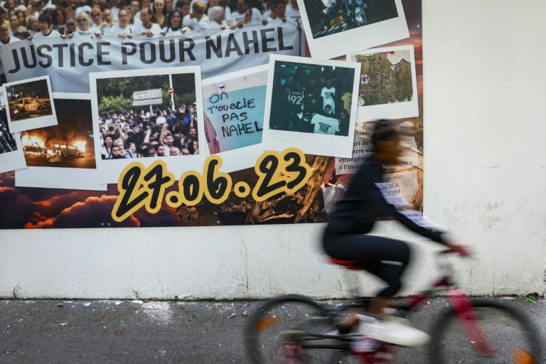 Un cycliste passe, à Nanterre, au nord-ouest de Paris, le 6 juin 2024, devant une fresque en hommage à Nahel, tué à 17 ans l'an dernier par un policier lors d'un contrôle (Geoffroy VAN DER HASSELT)