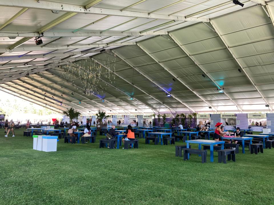 Festivalgoers enjoy the shade and grab food at the Indio Central Market on the first day of the Coachella Valley Music and Arts Festival on April 12, 2024.