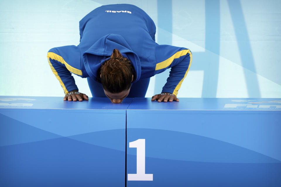 Gold medalist Ana Marcela Cunha of Brazil kisses the podium after the women's 5km open water swim at the World Swimming Championships in Yeosu, South Korea, Wednesday, July 17, 2019. (AP Photo/Mark Schiefelbein)