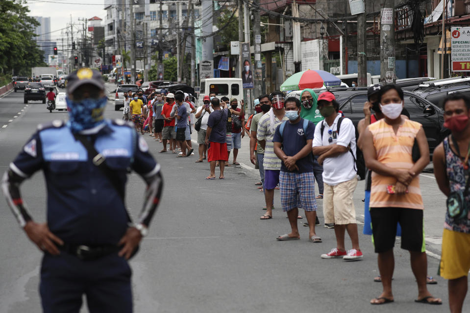 Jobless jeepney bus drivers line up to receive food donations as public transportation was again restricted during the lockdown in Quezon city, Philippines on Friday, Aug. 7, 2020. The capital and outlying provinces returned to another lockdown after medical groups warned that the country was waging a losing battle against the coronavirus amid an alarming surge in infections. (AP Photo/Aaron Favila)