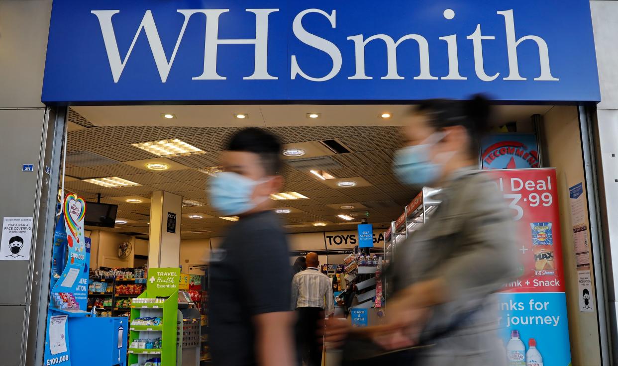 Pedestrians wearing a face mask or covering due to the COVID-19 pandemic, walk past a WH Smith store in London on August 5, 2020, following the announcement the retailer could cut 1500 jobs, and close up to 14 stores. - WH Smith said on Wednesday that it is planning to cut up to 1,500 jobs, due to the slow recovery from the COVID-19 lockdown. (Photo by Tolga Akmen / AFP) (Photo by TOLGA AKMEN/AFP via Getty Images)