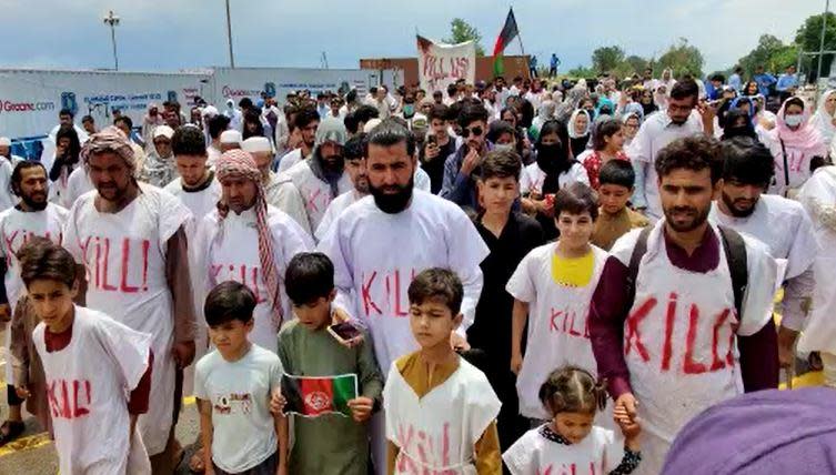 Fahim Baraki, second from right, and his children join other Afghan refugees in a protest march held by hundreds of refugee families to demand legal status as asylum seekers, in Islamabad, Pakistan, June 20, 2022. / Credit: CBS/Sami Yousafzai