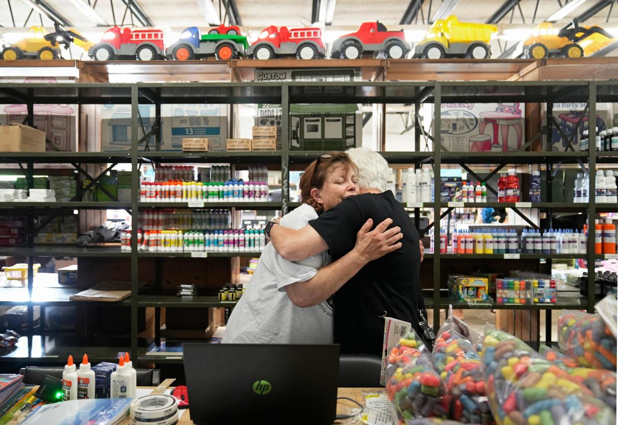 Barb Rohrbacher, whose son owns Star Beacon Products in Grandview Heights, embraces her friend and high school classmate Deb Webber of Pickerington at the store on Tuesday, the first day of the store's going-out-of-business sale.