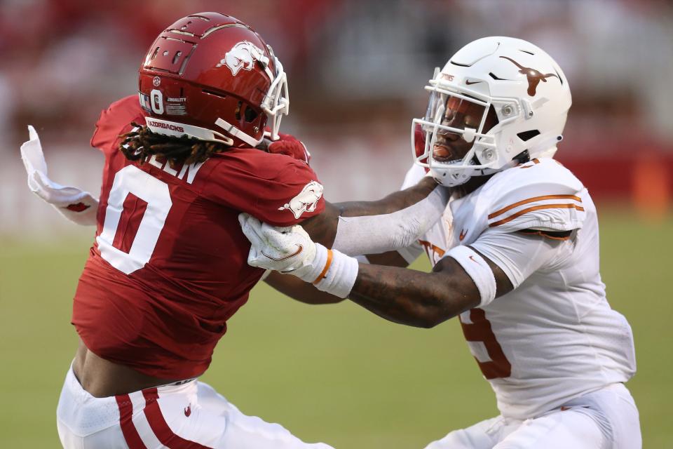 Sep 11, 2021; Fayetteville, Arkansas, USA; Texas Longhorns defensive back Josh Thompson (9) tackles Arkansas Razorbacks running back AJ Green (0) during the second quarter at Donald W. Reynolds Razorback Stadium.