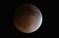 The moon turns an orange hue during a total lunar eclipse on Tuesday, April 15, 2014, in the sky above Phoenix. On April 29, the Southern Hemisphere will be treated to a type of solar eclipse. In all, four eclipses will occur this year, two lunar and two solar. (AP Photo/Ross D. Franklin)