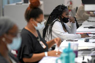 Kandice Childress, derecha, trabaja en las instalaciones de rastreo de contactos del Departamento de Salud Pública del condado Harris, el jueves 25 de junio de 2020, en Houston, Texas. (AP Foto/David J. Phillip)