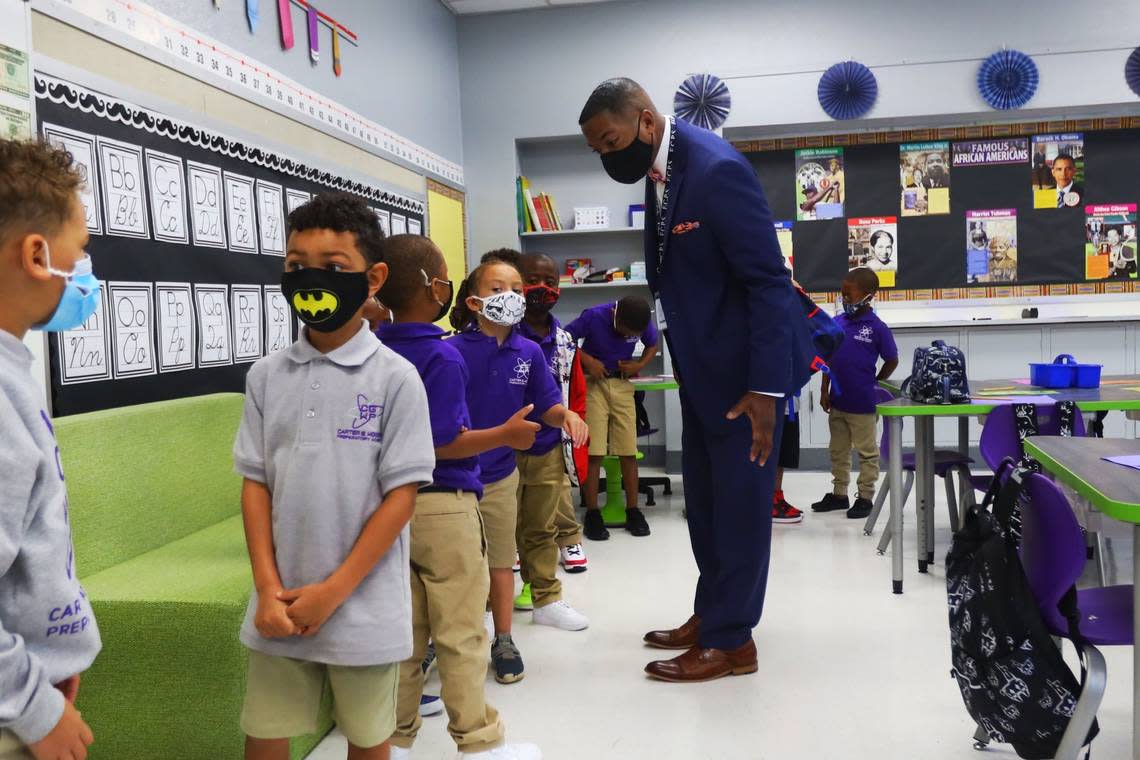 Superintendent Demetrus Liggins greets first grade students on their first day of school, August 11, 2021, at the new Carter G Woodson Preparatory academy on East Sixth St.
