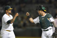 Oakland Athletics pitcher Frankie Montas, left, is greeted by catcher Yan Gomes as they walk off the field during the sixth inning of a baseball game against the Houston Astros in Oakland, Calif., Friday, Sept. 24, 2021. (AP Photo/Jeff Chiu)