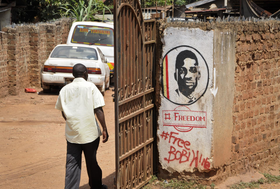 A man walks past graffiti in support of pop star-turned-opposition lawmaker Bobi Wine, whose real name is Kyagulanyi Ssentamu, in the Kamwokya neighborhood where he has many supporters, in Kampala, Uganda Thursday, Sept. 20, 2018. Security forces took Bobi Wine into custody when he arrived from the United States on Thursday, angering his supporters, while authorities barred public gatherings. (AP Photo/Ronald Kabuubi)