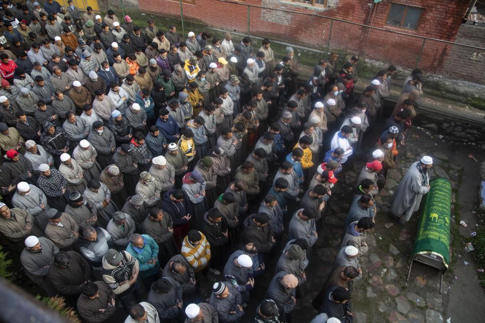 Kashmiri villagers offer funeral prayer near the coffin of elected official Riyaz Ahmad in Sopore 55 kilometers (34 miles) north of Srinagar, Indian controlled Kashmir, Monday, March. 29, 2021. Gunmen killed an elected official of India's ruling party and a policeman in disputed Kashmir on Monday, police said. Police blamed anti-India militants for the attack. None of the rebel groups that have been fighting against Indian rule since 1989 immediately claimed responsibility for the attack. (AP Photo/Mukhtar Khan).