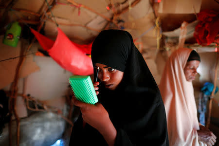 Zeinab, 14, applies her makeup before heading to school inside her shelter at a camp for internally displaced people from drought-hit areas in Dollow, Somalia April 4, 2017. REUTERS/Zohra Bensemra