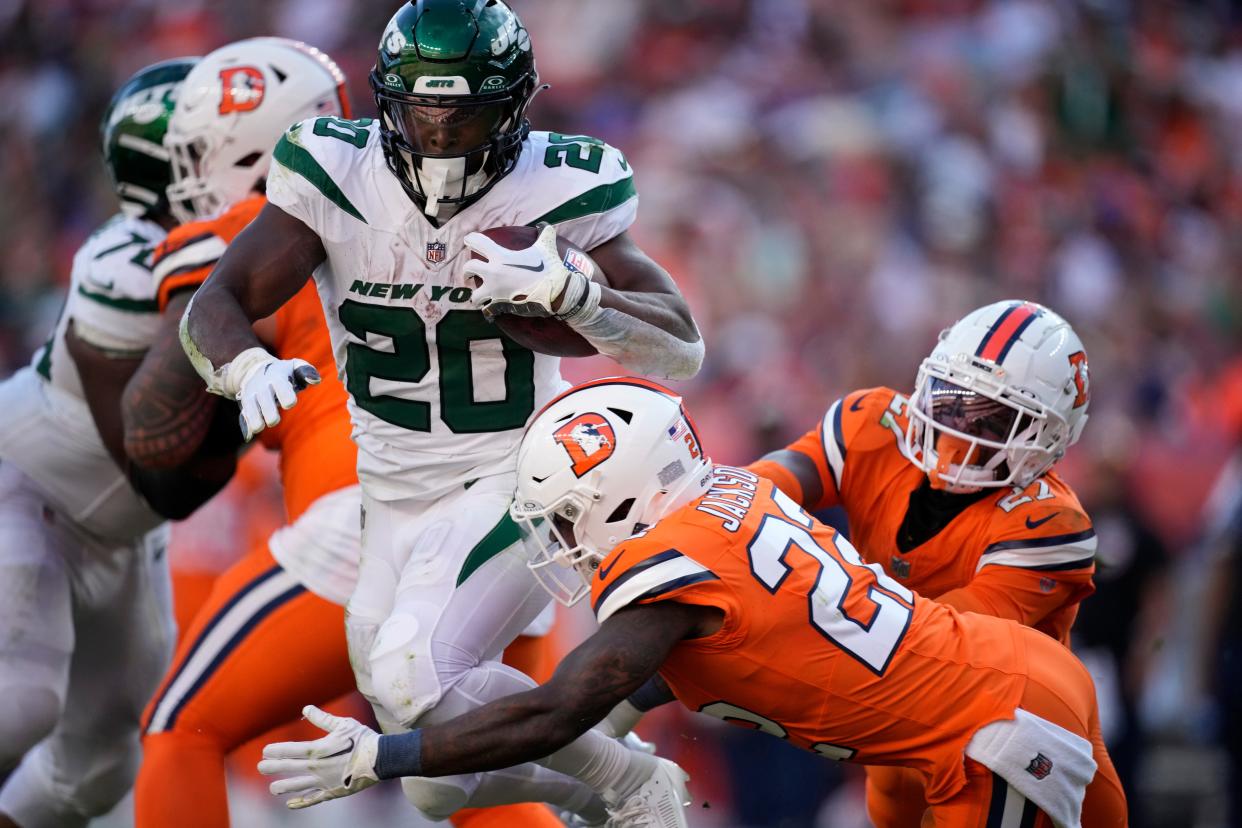 New York Jets running back Breece Hall (20) drives past Denver Broncos safety Kareem Jackson (22) in the second half of an NFL football game Sunday, Oct. 8, 2023, in Denver.