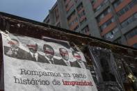 A banner showing images of several Mexican former presidents, obscuring their eyes with red bars, and calling for citizens to participate in a referendum on whether ex-presidents should be tried for their alleged crimes during their time in office, hangs from a wall in Mexico, City. Sunday, Aug. 1, 2021. (AP Photo/Christian Palma)