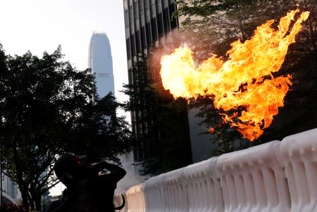 An anti-government protester throws a Molotov cocktail during a demonstration near Central Government Complex in Hong Kong