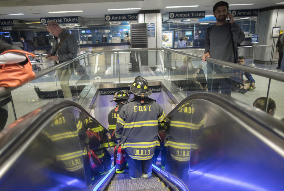 New York Firefighters make their way to a track at Penn Station, Friday, April 14, 2017, in New York. A New Jersey Transit train with about 1,200 passengers aboard is stuck in a Hudson River tunnel between New York and New Jersey. Authorities say the Northeast Corridor train became disabled Friday due to an Amtrak overhead power problem. (AP Photo/Mary Altaffer)