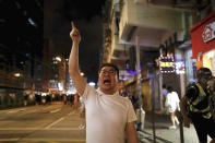 A man shouts at policemen as protesters face off with policemen in Hong Kong, Wednesday, Aug. 14, 2019. German Chancellor Angela Merkel is calling for a peaceful solution to the unrest in Hong Kong amid fears China could use force to quell pro-democracy protests. (AP Photo/Vincent Yu)