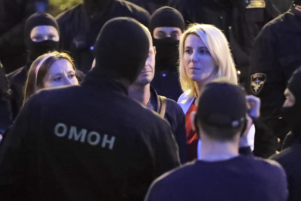 Two women talk with police surrounded protesters during a Belarusian opposition supporters rally at Independence Square in Minsk, Belarus, Wednesday, Aug. 26, 2020. Protests demanding the resignation of Belarus' authoritarian President Alexander Lukashenko have entered their 18th straight day on Wednesday. (AP Photo/Sergei Grits)