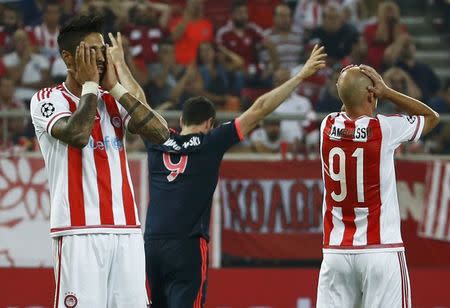 Olympiacos players react as Bayern Munich's Robert Lewandowski (C) celebrates a goal during their Champions League group F soccer match at the Karaiskakis stadium in Piraeus, near Athens, Greece, September 16, 2015. REUTERS/Paul Hanna