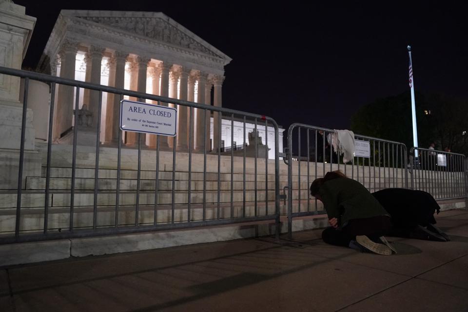 A women cries while kneeling in front of the US Supreme Court in Washington, DC, on May 2, 2022. - The Supreme Court is poised to strike down the right to abortion in the US, according to a leaked draft of a majority opinion that would shred nearly 50 years of constitutional protections. The draft, obtained by Politico, was written by Justice Samuel Alito, and has been circulated inside the conservative-dominated court, the news outlet reported. Politico stressed that the document it obtained is a  draft and opinions could change. The court is expected to issue a decision by June. The draft opinion calls the landmark 1973 Roe v Wade decision 