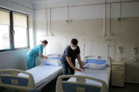 Medical staff check an empty ward, reserved for possible COVID-19 patients, at the Colentina Hospital in Bucharest, Romania, Thursday, Feb. 25, 2021. A year ago, Romania reported its first case of COVID-19, prompting the country's strapped medical system to turn its focus to treating COVID-19 patients. As a result, many patients with other conditions — including HIV but also cancer and other illnesses — have either been denied critical care or stopped going to their regular appointments, fearful of becoming infected.(AP Photo/Vadim Ghirda)