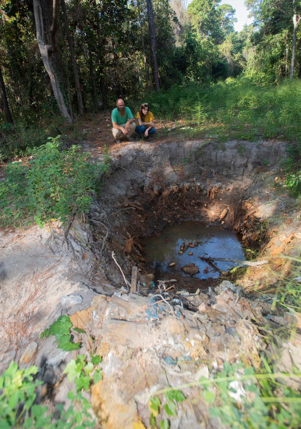 Abbey Rodamaker and her husband Jeff inspect the trash and garbage that contaminates their Gulf Breeze property on Wednesday, Oct. 9, 2019. The Rodamakers bought the six acres of secluded land off Highway 98 to build their dream home only to discover it was once used as a landfill.