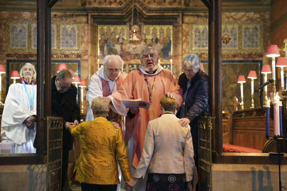 Reverend Catherine Bond, foreground left and Reverend Jane Pearce are blessed, at St John the Baptist church, in Felixstowe, after the use of prayers of blessing for same-sex couples in Church of England services were approved by the House of Bishops, in Suffolk, England, Sunday, Dec. 17, 2023.. Known as prayers of love and faith, the blessings can be used as part of regular services from Sunday, after they were approved by the House of Bishops just days earlier. (Joe Giddens/PA via AP)