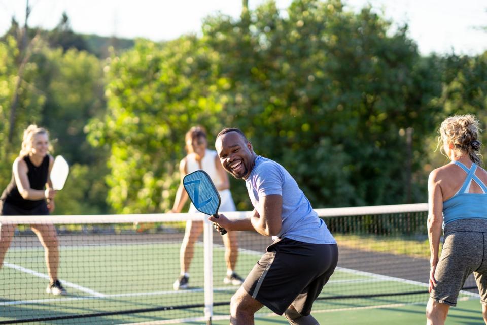 Four people playing pickleball.