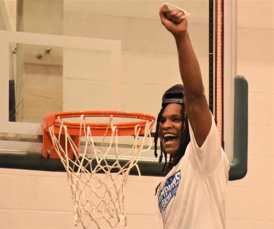 Brookdale Community College freshman Nick Williams holds up a piece of the net at Herkimer College following the Jersey Blues' win over Sandhills Community College in the NJCAA's Division III men's basketball championship game Saturday.