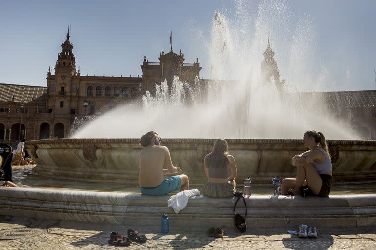 La gente se refresca en una fuente de Sevilla ante la ola de calor. Photo: Daniel Gonzalez Acuna/dpa