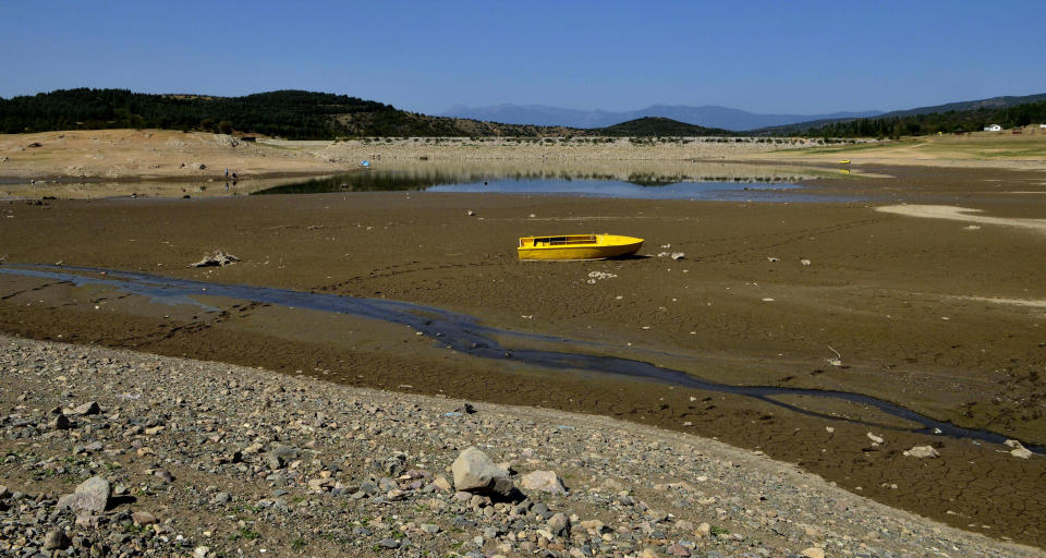 This Wednesday, Aug. 22, 2012 photo shows a boat stranded on the bottom of the dam Paljurci, near Bogdanci in southeastern Macedonia. The Paljurci dam, planned to irrigate land in the surrounding area, is almost empty due to the long period without rain in this Balkan country. This year, farmers all over the Balkans are turning to God for help. After the harshest winter in decades, the Balkans in the southeast of Europe is now facing its hottest summer and the worst drought in what officials across the region say is nearly 40 years. The record-setting average temperatures _ which scientists say have been steadily rising over the past years as the result of the global warming _ have ravaged crops, vegetable, fruit and power production in the region which is already badly hit by the global economic crisis. (AP Photo/Boris Grdanoski)