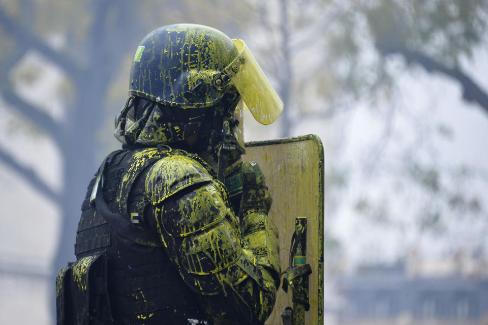 A riot police officer covered with yellow paint secures the Arc de Triomphe area during the “yellow vest” protests on Dec. 1, 2018, in Paris. (Photo: Aurelien Meunier/Getty Images)