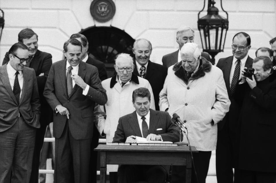 (Original Caption) In a ceremony on the South Lawn, President Reagan signs a $165 billion bill, to save Social Security from financial collapse. Behind Reagan is (L-R), Senator Robert Dole, (R.-Kans.), Rep. Claude Pepper, (D-Fla.), Rep. Robert Michel, (R-Ill.), House Speaker Thomas 