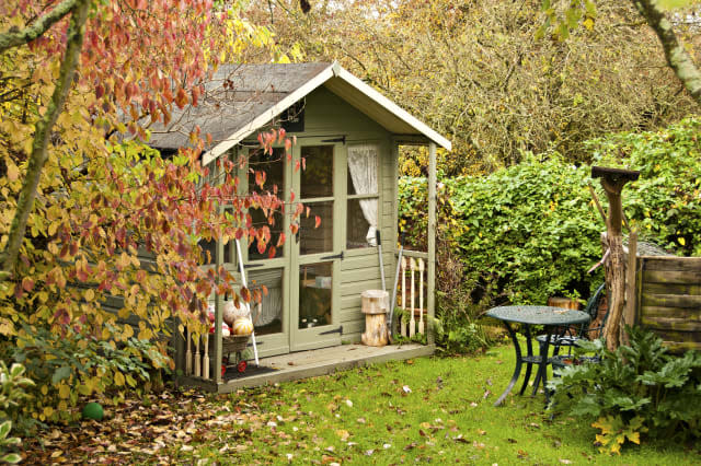 Fall leaves surround the summerhouse at the bottom of the garden