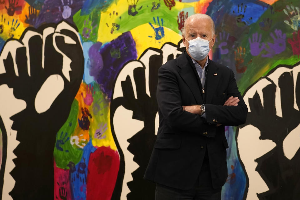 FILE - In this Nov. 3, 2020, file photo, Democratic presidential candidate former Vice President Joe Biden pauses in front of a mural during visit to The Warehouse teen center in Wilmington, Del. A tough road lies ahead for Biden who will need to chart a path forward to unite a bitterly divided nation and address America’s fraught history of racism that manifested this year through the convergence of three national crises. (AP Photo/Carolyn Kaster, File)