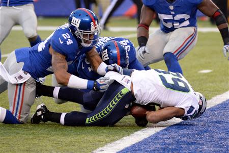 Dec 15, 2013; East Rutherford, NJ, USA; Seattle Seahawks wide receiver Doug Baldwin (89) scores a touchdown past New York Giants defensive end Mathias Kiwanuka (94) and cornerback Terrell Thomas (24) in the second half during the game at MetLife Stadium. Mandatory Credit: Robert Deutsch-USA TODAY Sports