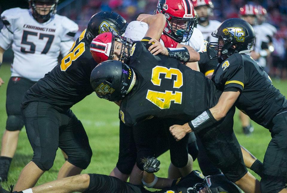 Colonel Crawford's Carson Feichtner (43), Nick Teglovic (58) and Derek Horsley gang tackle a Cardington player.