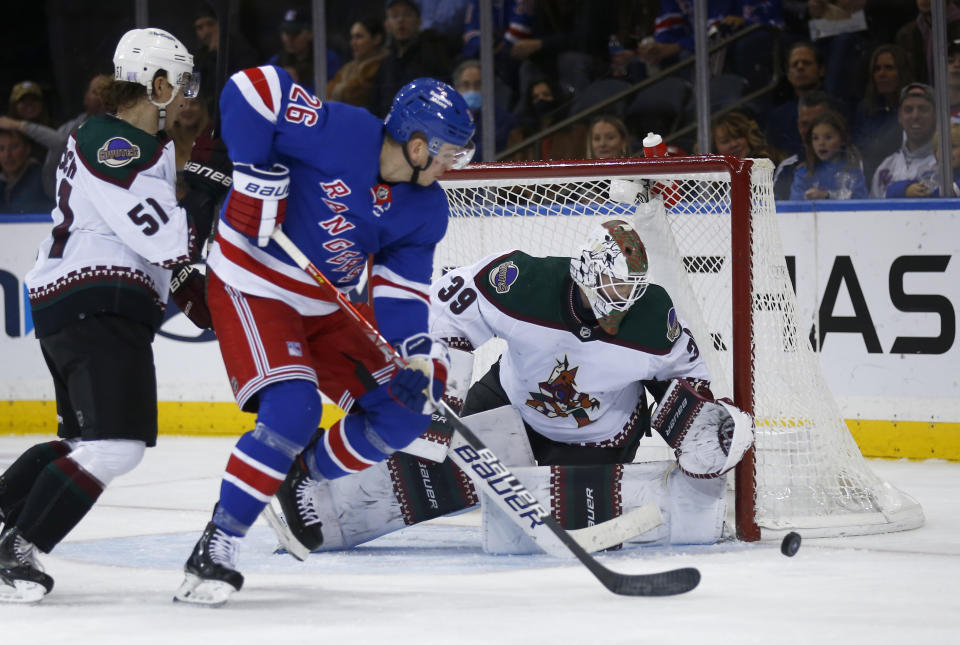 Arizona Coyotes goalie Connor Ingram makes the save as Coyotes defenseman Troy Stecher (51) and New York Rangers left wing Jimmy Vesey (26) battle for position in front of the net during the first period of an NHL hockey game, Sunday, Nov. 13, 2022, in New York. (AP Photo/John Munson)