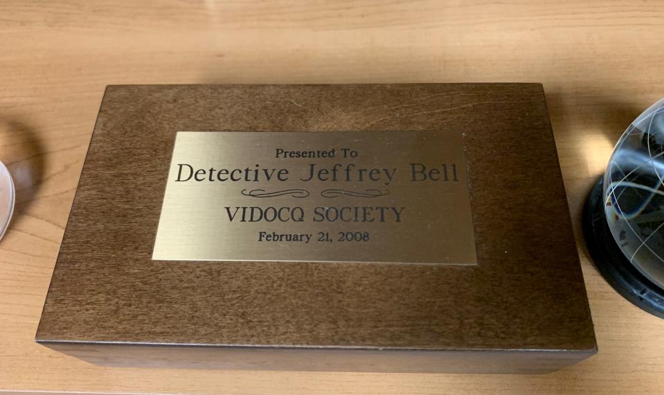 The VIDOCQ Society award to Detective Jeff Bell from February 21, 2008, in recognition of his hard work and dedication to solving the Jennifer Servo case. This award sits prominently on a book shelf in Bell's office.
