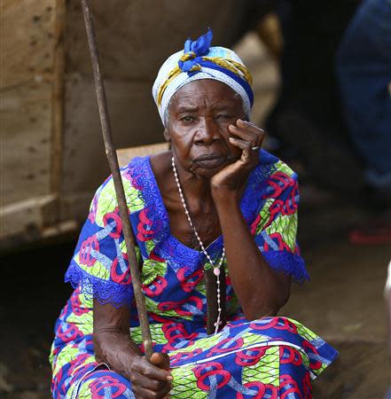 A woman waits during the second day of rescue operations after a boat carrying mostly Congolese refugees capsized in Lake Albert along the Uganda-Democratic Republic of Congo border, March 23, 2014. REUTERS/Edward Echwalu