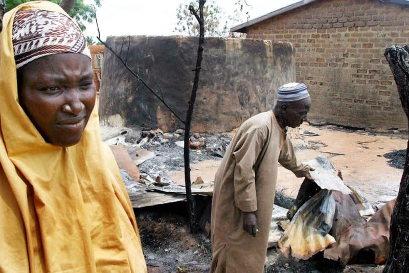 A Nigerian Muslim woman and her husband assess the damage to their home in the town of Yelwa, Friday on May 7, 2004. On May 2, Nigerian Christian militants attacked the Muslim town of Yelwa with firearms and machetes in reprisal for an attack in February 2004. File Photo by Stringer/EPA