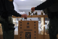 FILE -In this March 15, 2018 photo, two undercover Los Angeles County sheriff's deputies dump marijuana into an evidence bag during a raid at an illegal marijuana dispensary during a raid in Compton, Calif. An unwelcome trend is emerging in California, as the nation's most populous state enters its fifth year of broad legal marijuana sales. Industry experts say a growing number of license holders are secretly operating in the illegal market — working both sides of the economy to make ends meet. (AP Photo/Jae C. Hong,File)