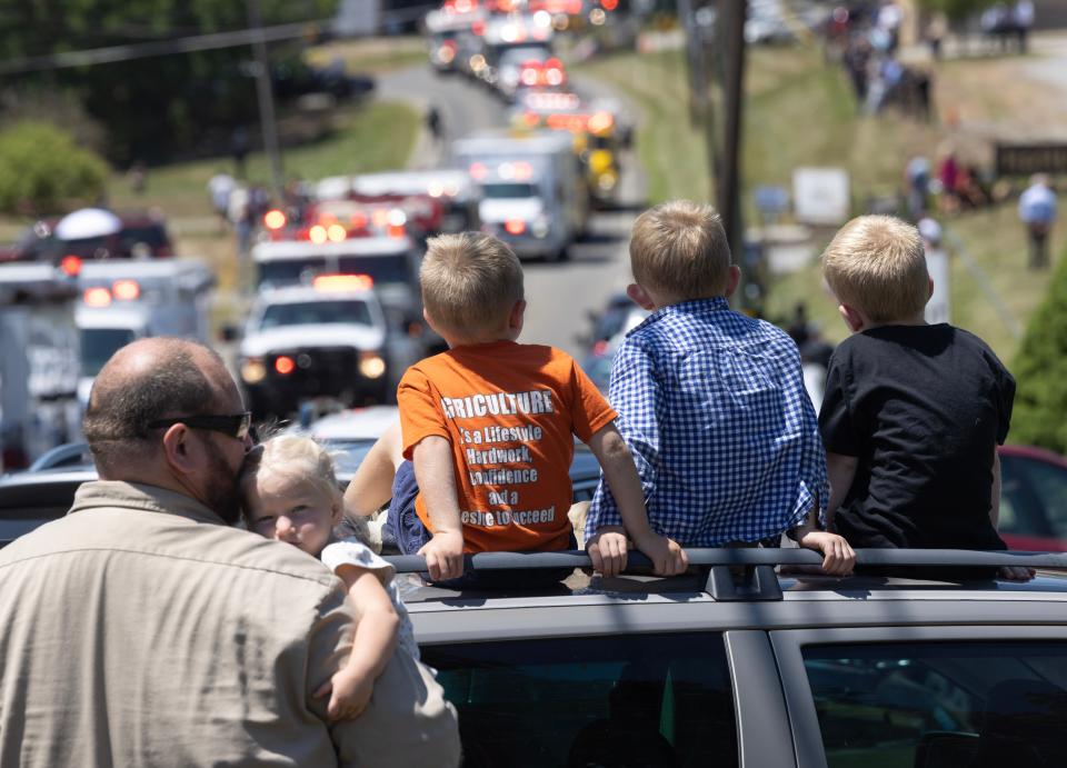 A family watches the fire engines leave outside Cabot United Methodist church Friday, July 19th for the funeral of Corey Comperatore the Buffalo Township man killed at SaturdayÕs rally for former President Donald Trump from a would-be assassinÕs stray bullet.