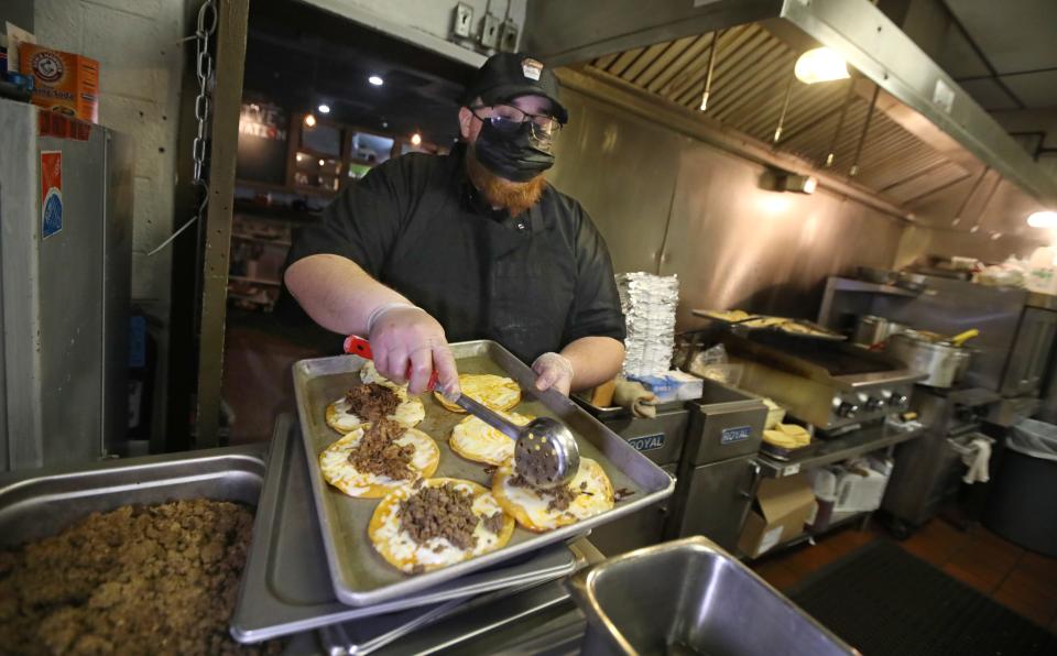 Chef Cordero Rivera loads ground beef onto a New York chopped cheese taco on April 15, 2021, at TacoDero's weekly Taco Tuesday pop-up at Flour City Station in Rochester, New York.