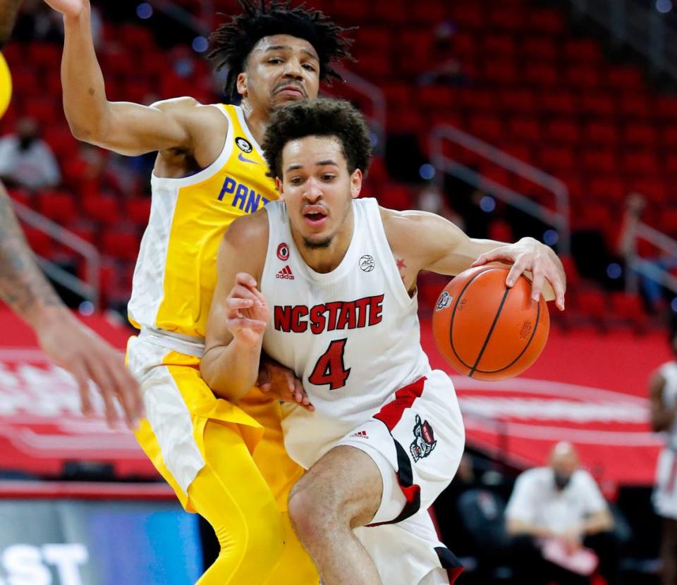 N.C. State’s Jericole Hellems (4) drives by Pittsburgh’s Ithiel Horton (0) during the first half of N.C. State’s game against Pittsburgh at PNC Arena in Raleigh, N.C., Sunday, February 28, 2021.